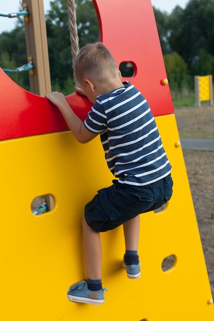 Ragazzino sveglio che gioca nel parco giochi