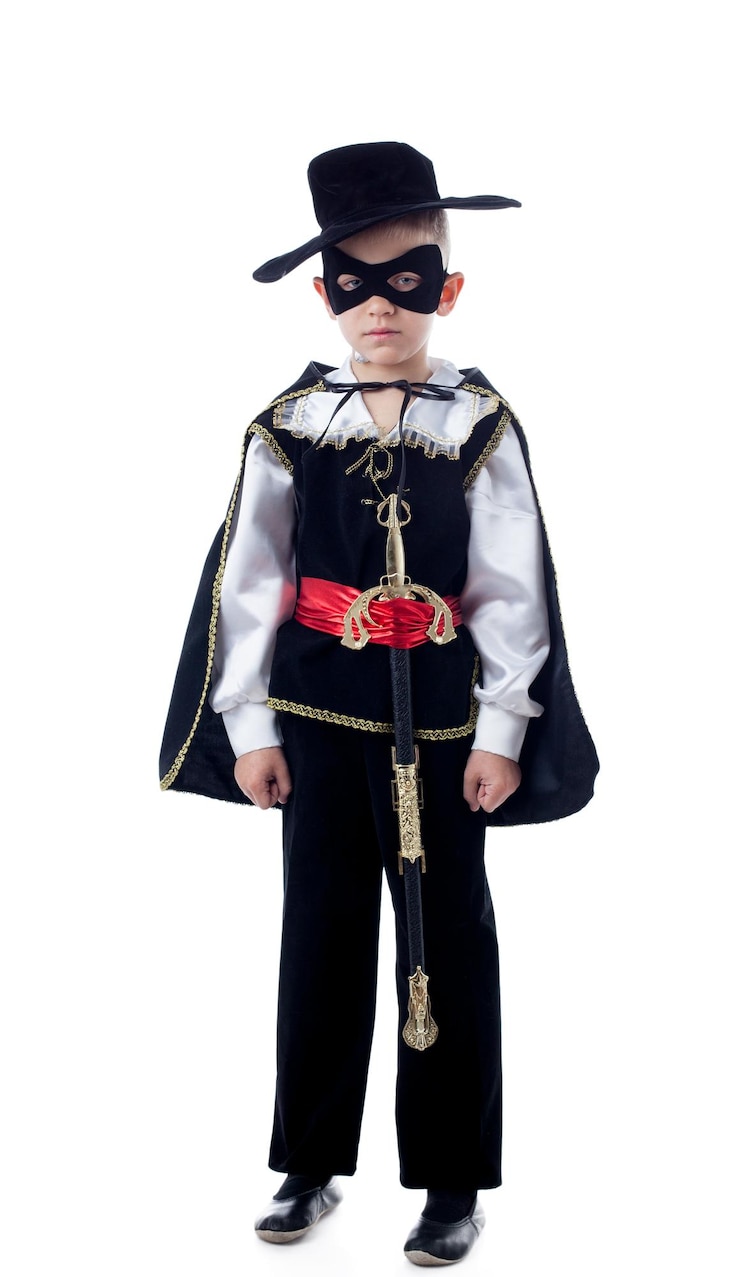 Foto ragazzino sveglio che posa in costume da zorro