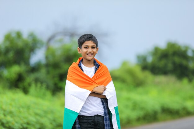 Ragazzino sveglio con la bandiera tricolore nazionale indiana