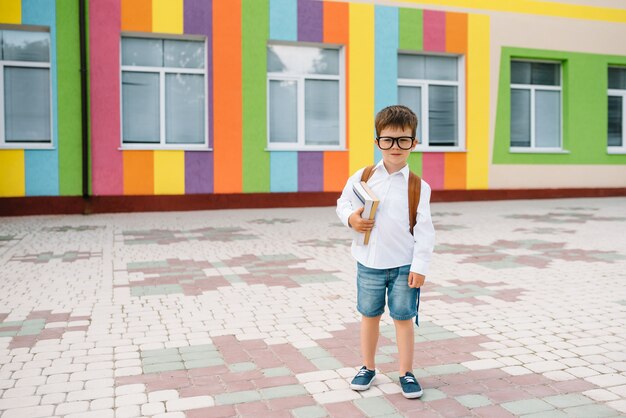 Ragazzino sveglio con uno zaino e libri