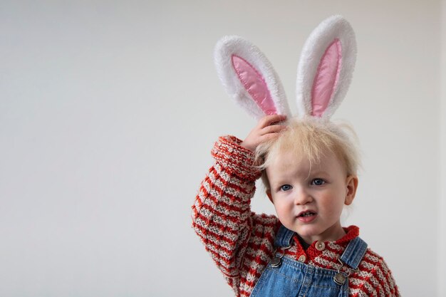 Ragazzino sveglio del bambino che celebra la pasqua che porta le orecchie del coniglietto di pasqua