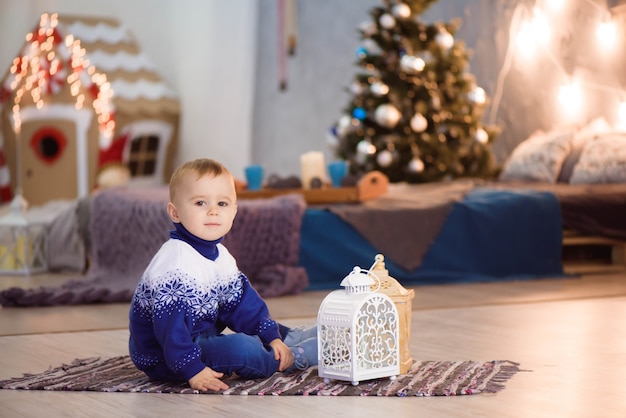 Ragazzino sveglio vicino a casa sua decorata per Natale. Buon Natale e Felice Anno nuovo.