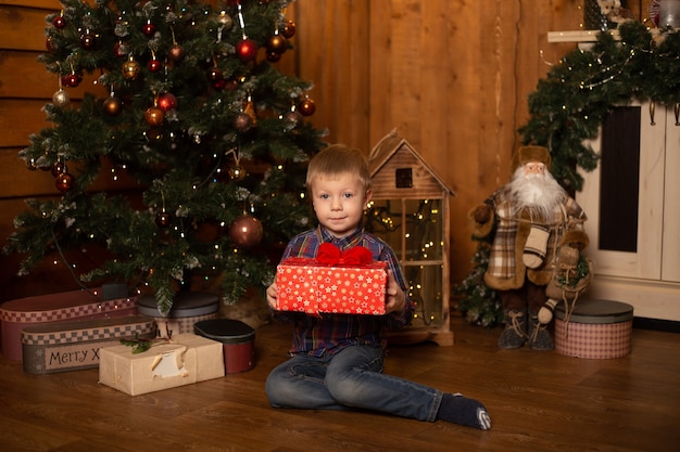 Ragazzino sveglio vicino all'albero di Natale