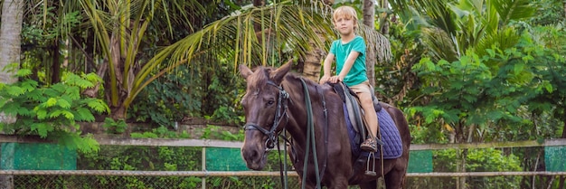 Ragazzo a cavallo che esegue esercizi su banner a cavallo formato lungo