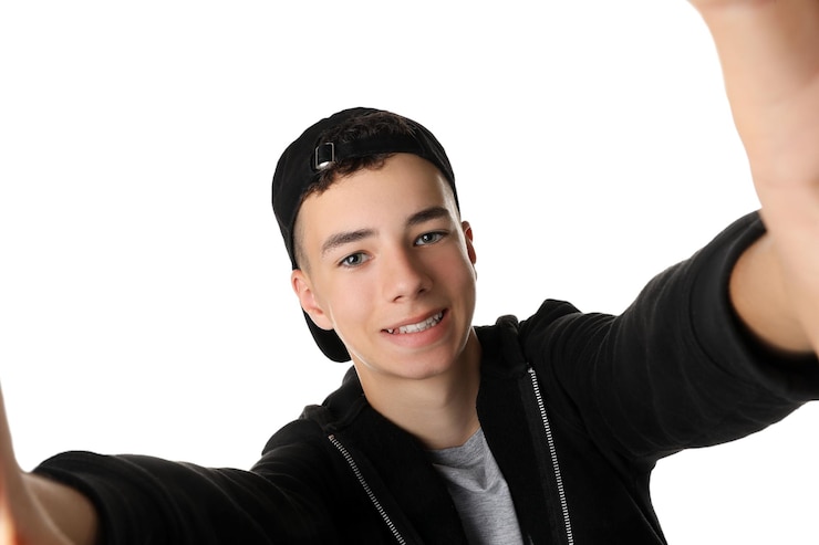 Foto ragazzo adolescente che si fa un selfie su sfondo bianco