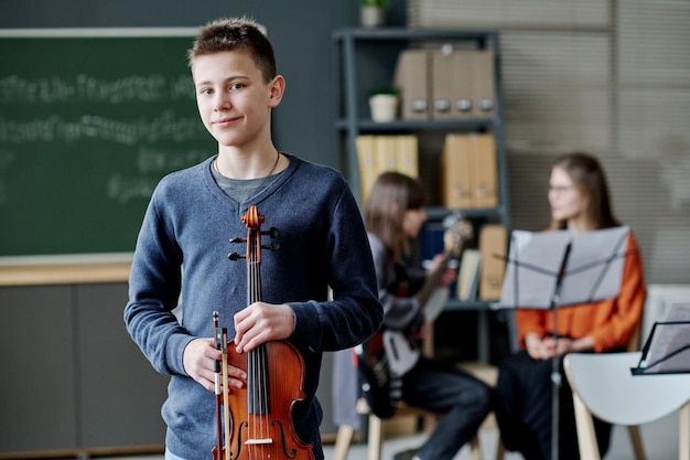 Ragazzo adolescente con il violino in classe