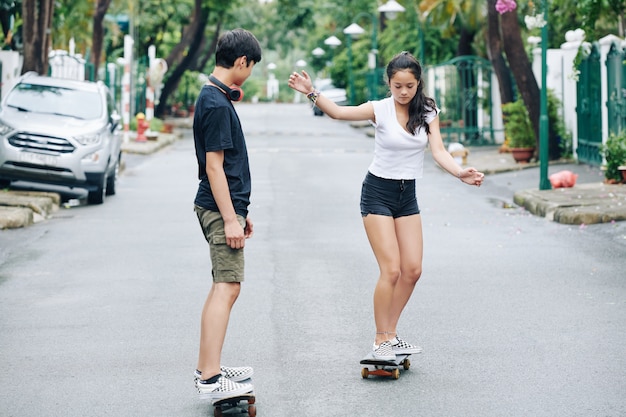 Ragazzo adolescente insegna alla sorella di skateboard