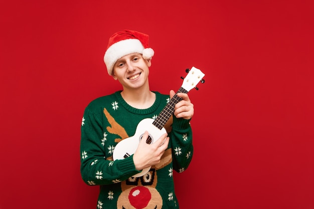 Ragazzo adolescente ritratto con maglione di Natale con ukulele