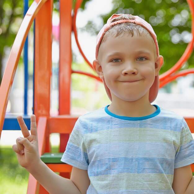 Ragazzo adorabile nel parco giochi estivo