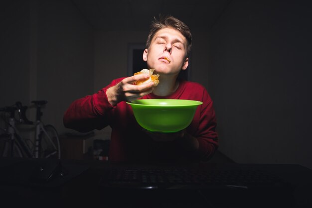 Ragazzo al computer di casa di notte