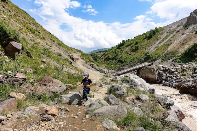 Ragazzo al fiume KyzylKol circondato dalle montagne del Caucaso vicino a Elbrus Jilysu Russia