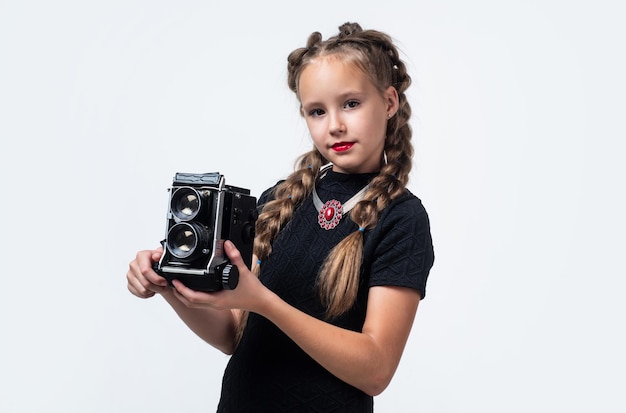 Ragazzo alla moda con fotocamera retrò che fa foto isolato su giornalista bianco