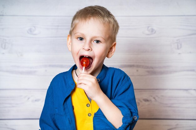 Ragazzo alla moda con lecca-lecca Emozioni del bambino