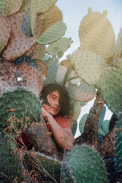 Ragazzo alla moda nella natura dei cactus