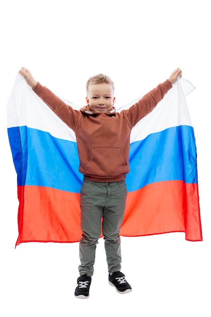Ragazzo allegro che tiene la bandiera russa. Festa dell'indipendenza e patriottismo. Isolato su sfondo bianco. Verticale.