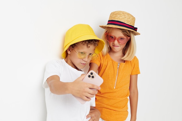 Ragazzo allegro e ragazza in occhiali alla moda cappelli selfie in posa