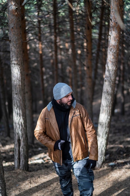 ragazzo alto con la barba sulla montagna che indossa abiti caldi e posa