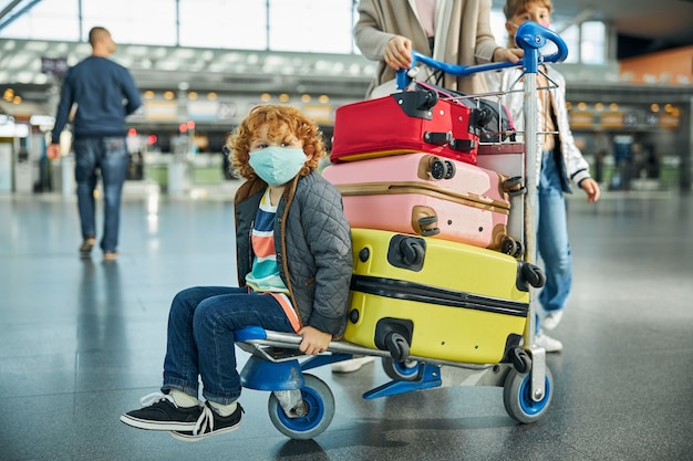 Ragazzo annoiato che si guarda intorno al terminal dell'aeroporto