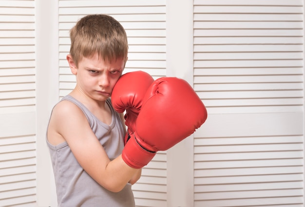 Ragazzo arrabbiato in guantoni da boxe rossi.