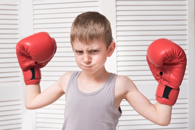 Ragazzo arrabbiato in guantoni da boxe rossi.