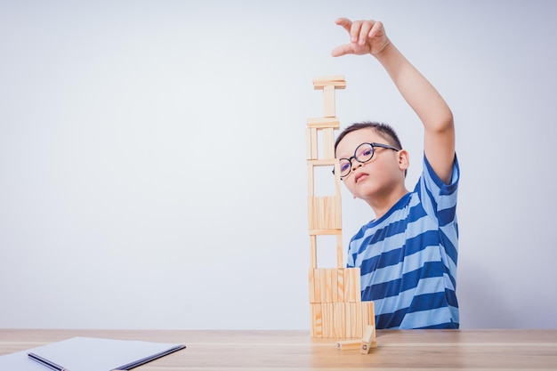 Ragazzo asiatico che gioca con un puzzle di legno