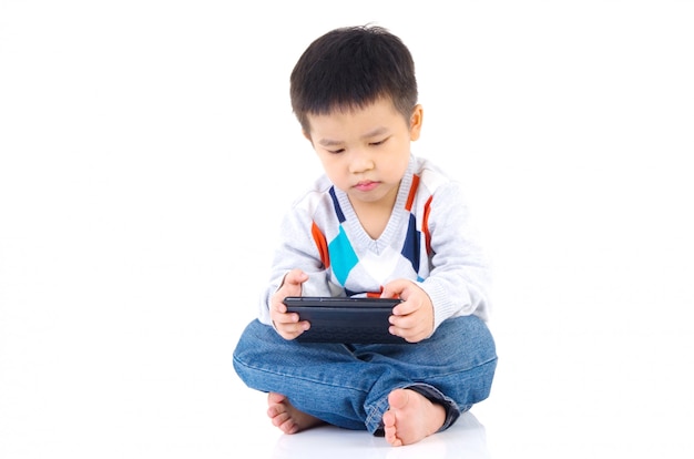 Ragazzo asiatico che gioca gioco sulla tavoletta digitale