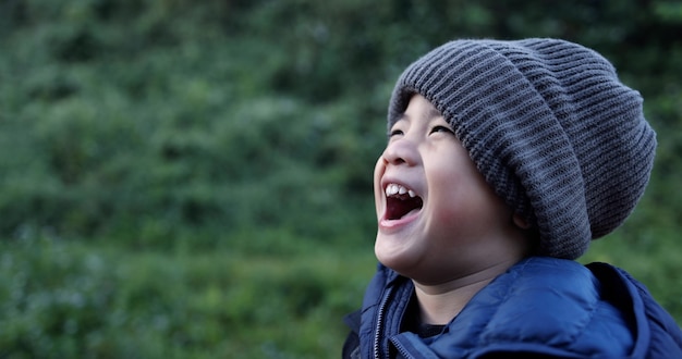 Ragazzo asiatico che indossa un cappello di lana e ride nella stagione invernale