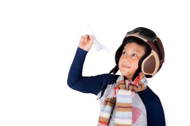 Ragazzo asiatico che indossa un casco da volo vintage che tiene in mano un aereo di carta isolato su uno sfondo bianco