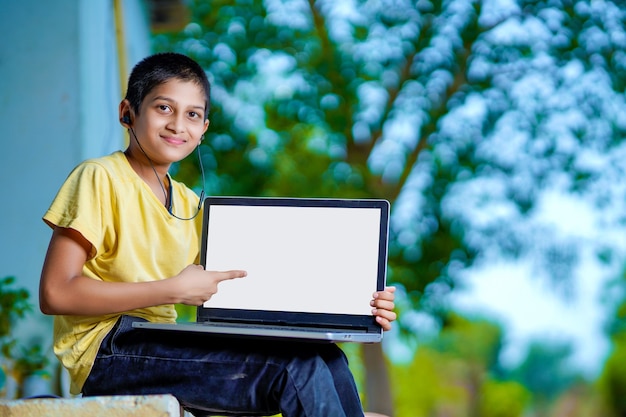 Ragazzo asiatico che utilizza un computer portatile per studiare online l'istruzione a casa durante la quarantena domestica. homeschooling, studio online, quarantena domestica, apprendimento online, virus corona o concetto di tecnologia educativa