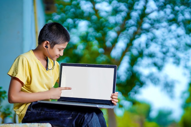 Ragazzo asiatico che utilizza un computer portatile per studiare online l'istruzione a casa durante la quarantena domestica. homeschooling, studio online, quarantena domestica, apprendimento online, virus corona o concetto di tecnologia educativa