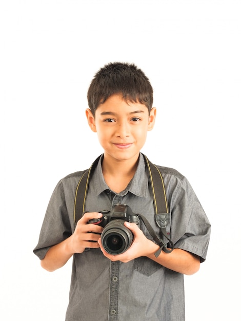 Ragazzo asiatico con la macchina fotografica di DSLR su fondo bianco