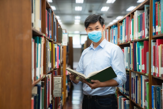 Ragazzo asiatico studente universitario che indossa maschera medica protettiva per il viso