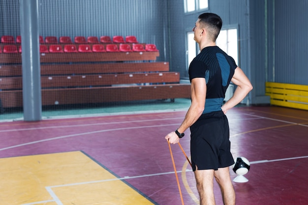 Ragazzo atletico in abbigliamento sportivo e fitness tracker facendo esercizi in palestra.