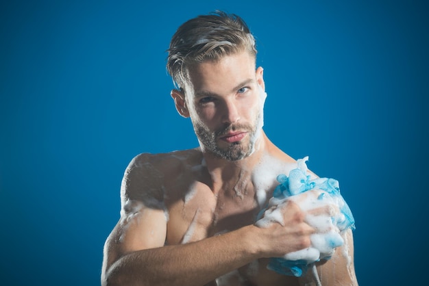 Ragazzo attraente che fa la doccia con una spugna di sapone dopo una lunga giornata mattutina che lava la vita quotidiana spa