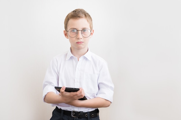 Ragazzo attraente con un tablet con gli occhiali e una camicia bianca.