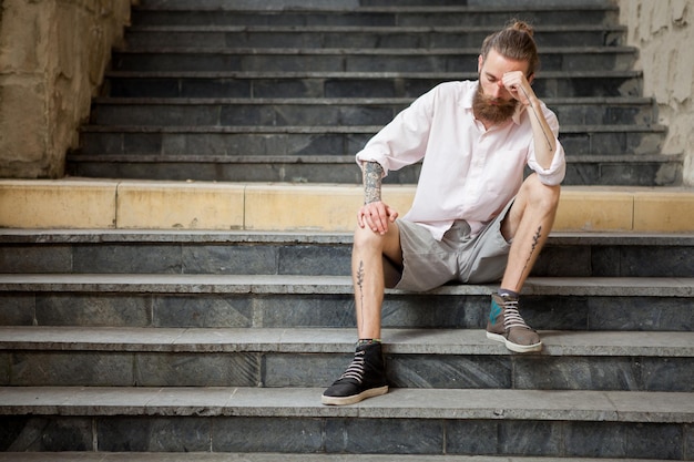 Ragazzo barbuto in posa all'aperto in città