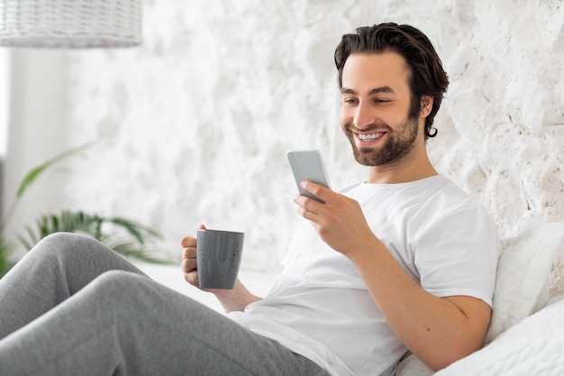 Ragazzo barbuto rilassato che si rilassa sul letto a casa