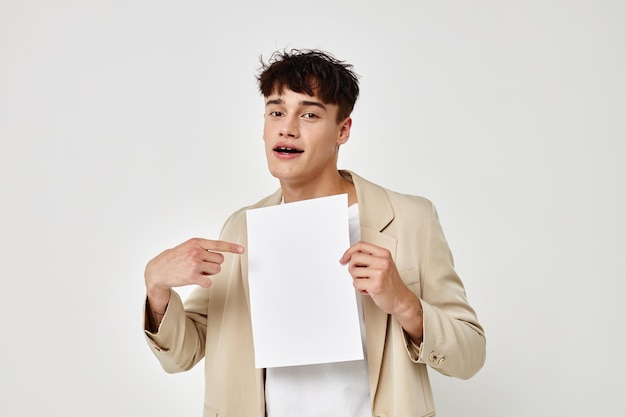 Ragazzo bello in uno studio del modello del taccuino del copyspace del vestito beige