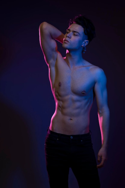 Ragazzo bello pompato con torsi nudi Ragazzo sportivo corpo maschile attraente Riprese in studio con filtri colorati