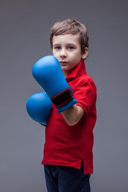 Ragazzo bello serio che posa in guantoni da boxe