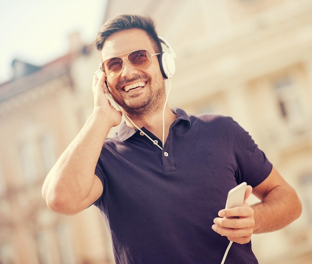 Ragazzo bello sorridente che ascolta la musica