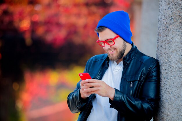 Ragazzo bianco che utilizza un telefono cellulare in un parco