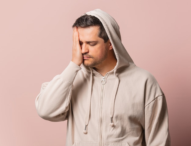 Ragazzo bianco stanco in felpa con cappuccio rosa