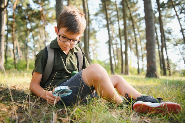 Ragazzo biologo o entomologo studia la natura Scout nella foresta Un adolescente studia gli insetti Biologia Geologia Spedizione nella foresta