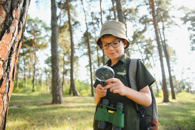 Ragazzo biologo o entomologo studia la natura Scout nella foresta Un adolescente studia gli insetti Biologia Geologia Spedizione nella foresta