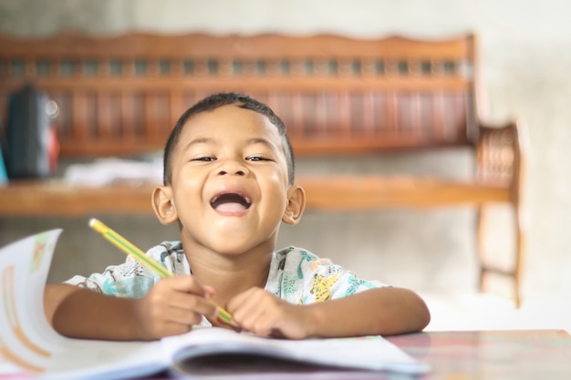 Ragazzo carino bambino che studia e pensa a casa.