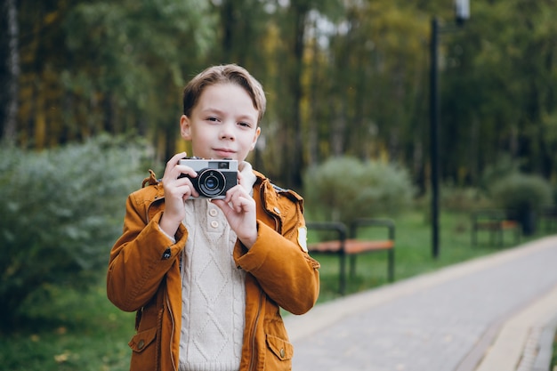 Ragazzo carino cammina e pone in un parco colorato autunno