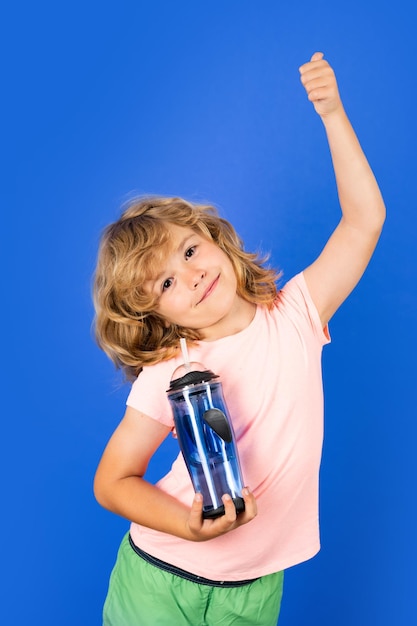 Ragazzo carino che beve acqua fresca isolato su sfondo studio ragazzino tiene un bicchiere d'acqua miniera