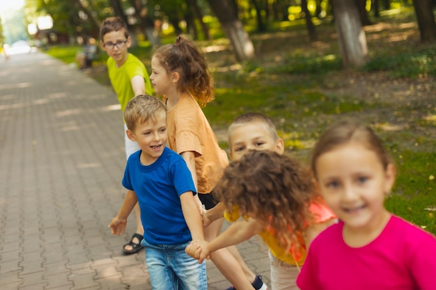 Ragazzo carino che gioca con gli amici all'aperto nel parco