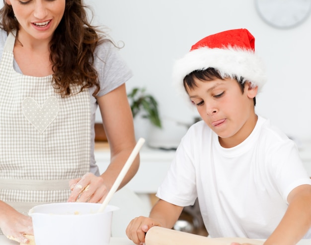 Ragazzo carino che prepara i biscotti di Natale con sua madre